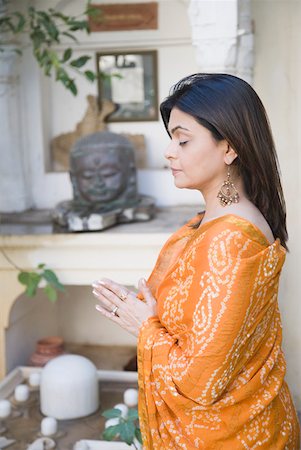 Mid adult woman praying in front of Lord Shiva Stock Photo - Premium Royalty-Free, Code: 630-01872898