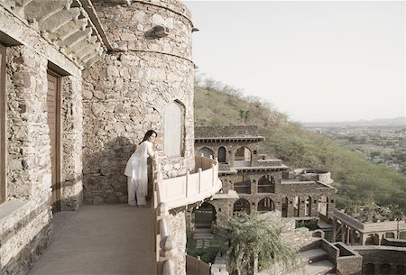rajasthan clothes for women - Side profile of a young woman leaning on the balcony of a fort, Neemrana Fort Palace, Neemrana, Alwar, Rajasthan, India Stock Photo - Premium Royalty-Free, Code: 630-01872967