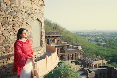 rajasthan clothes for women - Mid adult woman standing at the balcony of a fort, Neemrana Fort Palace, Neemrana, Alwar, Rajasthan, India Stock Photo - Premium Royalty-Free, Code: 630-01872969
