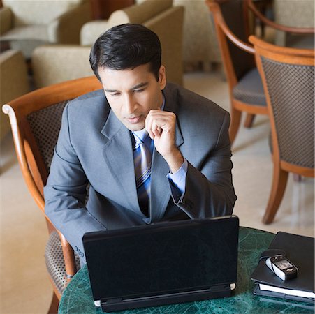Homme d'affaires travaillant sur un ordinateur portable dans un hôtel Photographie de stock - Premium Libres de Droits, Code: 630-01873125