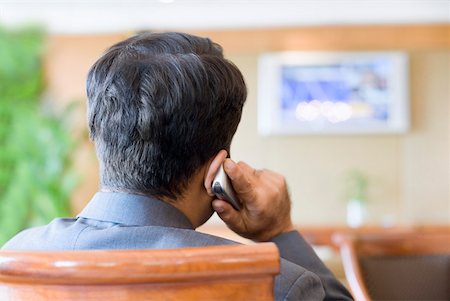 simsearch:630-01873072,k - Rear view of a businessman talking on a mobile phone in a lobby Stock Photo - Premium Royalty-Free, Code: 630-01873146