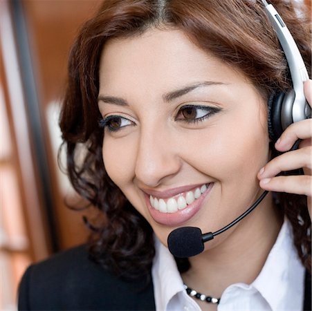 Close-up of a businesswoman wearing a headset and smiling Stock Photo - Premium Royalty-Free, Code: 630-01873155