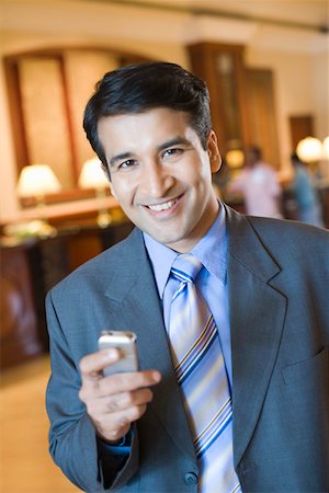 simsearch:630-01873072,k - Portrait of a businessman holding a mobile phone and smiling Stock Photo - Premium Royalty-Free, Code: 630-01873232