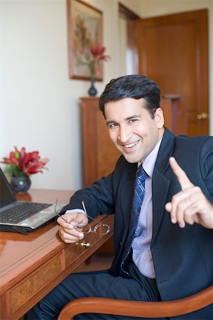Portrait d'un homme d'affaires assis devant un ordinateur portable et souriant Photographie de stock - Premium Libres de Droits, Code: 630-01873299