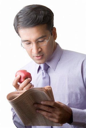 simsearch:640-01350815,k - Close-up of a businessman eating an apple and reading a newspaper Stock Photo - Premium Royalty-Free, Code: 630-01873378