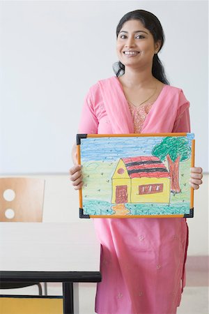 Portrait of a teacher holding a child's drawing and smiling Stock Photo - Premium Royalty-Free, Code: 630-01873491
