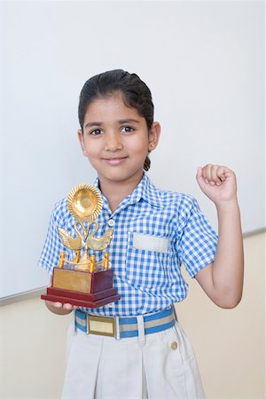 school girl skirt - Portrait of a schoolgirl holding a trophy and smiling Stock Photo - Premium Royalty-Free, Code: 630-01873517