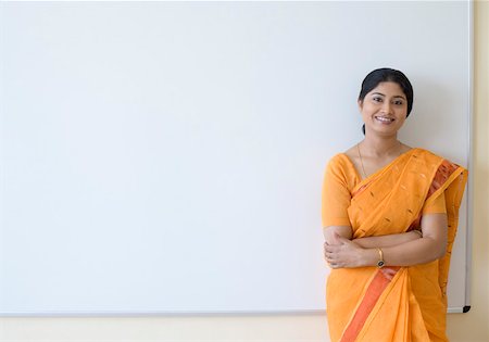 Portrait of a teacher standing with her arms crossed and smiling Stock Photo - Premium Royalty-Free, Code: 630-01873542