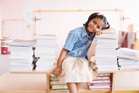 simsearch:630-01873514,k - Portrait of a schoolgirl leaning over a stack of books and smiling Foto de stock - Sin royalties Premium, Código: 630-01873615