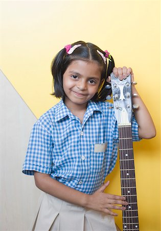 simsearch:630-01873514,k - Portrait of a schoolgirl standing with a guitar and smiling Foto de stock - Sin royalties Premium, Código: 630-01873623