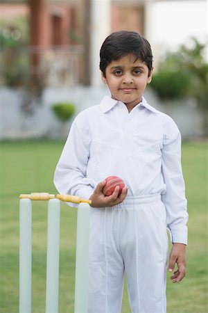 Portrait of a boy holding a cricket ball and smiling Stock Photo - Premium Royalty-Free, Code: 630-01873670