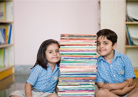 simsearch:630-01873514,k - School boy and a schoolgirl sitting on the floor with a stack of books Foto de stock - Sin royalties Premium, Código: 630-01873800