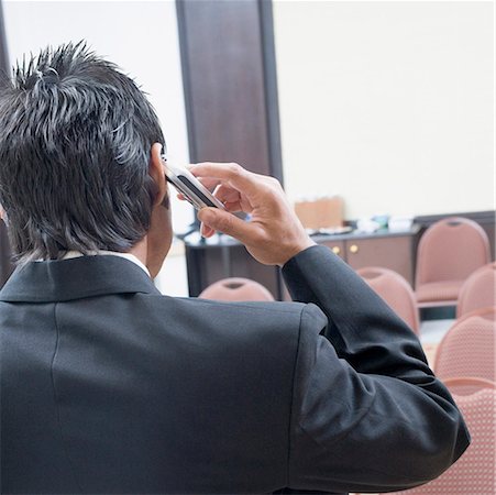 phone with indian man backside - Rear view of a businessman talking on a mobile phone Stock Photo - Premium Royalty-Free, Code: 630-01873875