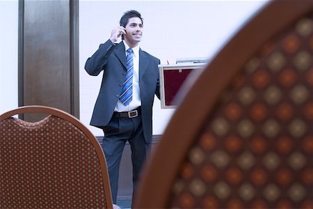 simsearch:630-01873072,k - Businessman standing in a conference room and talking on a mobile phone Stock Photo - Premium Royalty-Free, Code: 630-01873876