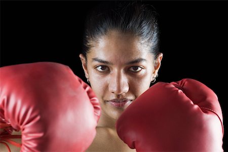female smirk - Portrait of a young woman wearing boxing gloves Stock Photo - Premium Royalty-Free, Code: 630-02219495