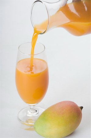 Close-up of mango with a glass of mango shake Stock Photo - Premium Royalty-Free, Code: 630-02219679