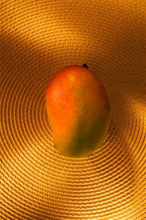 Close-up of a mango on a place mat Stock Photo - Premium Royalty-Free, Code: 630-02219871