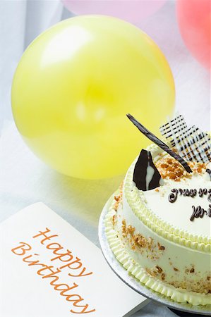 simsearch:630-02219911,k - Close-up of a butterscotch cake with a birthday card and balloons Stock Photo - Premium Royalty-Free, Code: 630-02219909
