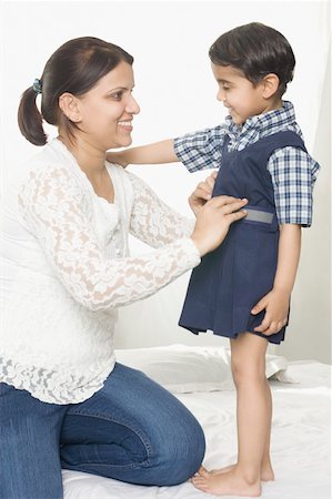 simsearch:630-02219943,k - Mid adult woman helping her daughter in wearing school uniform and smiling Stock Photo - Premium Royalty-Free, Code: 630-02219983