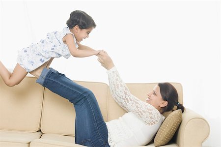 simsearch:630-02219943,k - Side profile of a mid adult woman with her daughter playing on a couch Stock Photo - Premium Royalty-Free, Code: 630-02220191