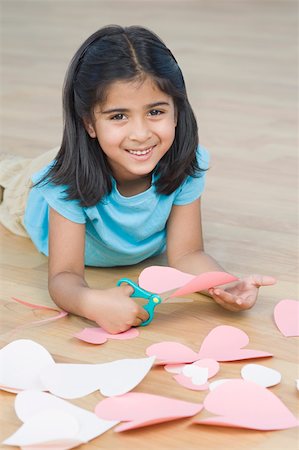 simsearch:630-02221120,k - Portrait of a girl cutting papers in heart shape and smiling Stock Photo - Premium Royalty-Free, Code: 630-02220237