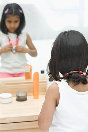 Rear view of a girl sitting in front of a dressing table Stock Photo - Premium Royalty-Free, Code: 630-02220230