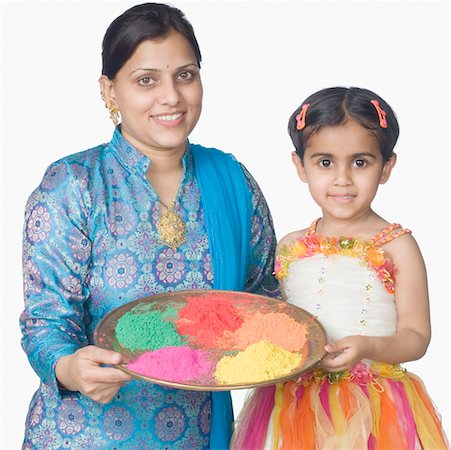 simsearch:630-02219943,k - Portrait of a mid adult woman and her daughter holding a plate of powder paint and smiling Stock Photo - Premium Royalty-Free, Code: 630-02220383