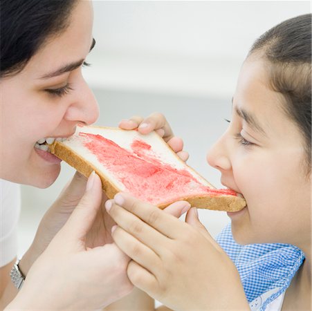 pic of indian kid eating breakfast - Close-up of a mid adult woman eating a bread Stock Photo - Premium Royalty-Free, Code: 630-02220524