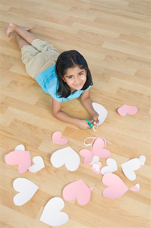 simsearch:630-02221120,k - Portrait of a girl cutting papers in heart shape and smiling Stock Photo - Premium Royalty-Free, Code: 630-02220613