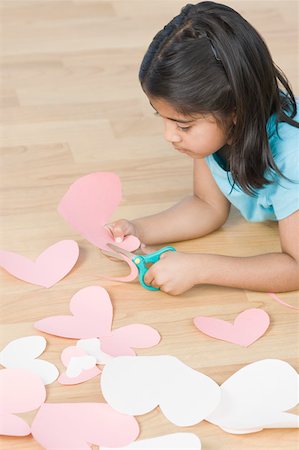 simsearch:630-02221120,k - Side profile of a girl cutting papers in heart shape Stock Photo - Premium Royalty-Free, Code: 630-02220802