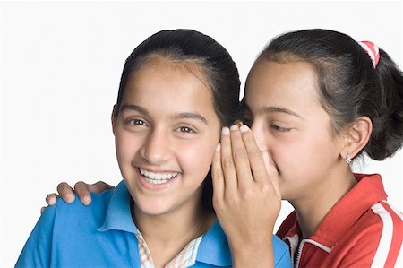 Girl whispering into her sister's ear Stock Photo - Premium Royalty-Free, Code: 630-02220826