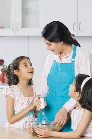 simsearch:630-02219943,k - Close-up of a mid adult woman with her two daughters cooking in the kitchen Stock Photo - Premium Royalty-Free, Code: 630-02220895