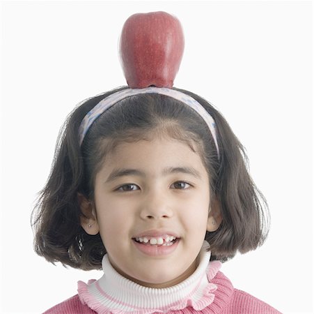 simsearch:630-02221120,k - Portrait of a girl balancing an apple on her head Stock Photo - Premium Royalty-Free, Code: 630-02220906