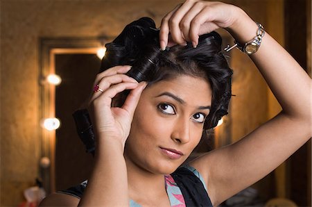 Close-up of a young woman adjusting her hair Stock Photo - Premium Royalty-Free, Code: 630-03479385