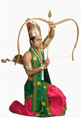 Young man in a character of Arjuna and holding a bow and arrow Stock Photo - Premium Royalty-Free, Code: 630-03479549