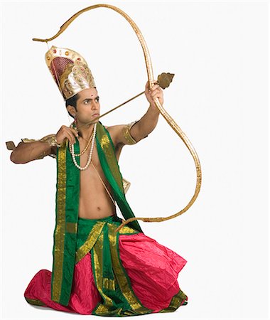 Young man in a character of Arjuna and holding a bow and arrow Stock Photo - Premium Royalty-Free, Code: 630-03479550