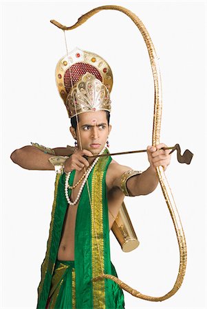 scorn - Young man in a character of Arjuna and holding a bow and arrow Stock Photo - Premium Royalty-Free, Code: 630-03479551