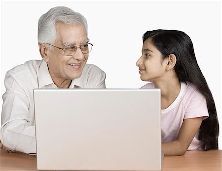 simsearch:630-03479683,k - Senior man using a laptop with his granddaughter and smiling Stock Photo - Premium Royalty-Free, Code: 630-03479584