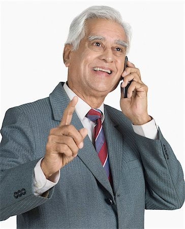 seniors using cell phone - Businessman talking on a mobile phone and smiling Stock Photo - Premium Royalty-Free, Code: 630-03479652