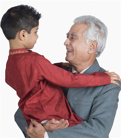 Senior man carrying his grandson and smiling Stock Photo - Premium Royalty-Free, Code: 630-03479664