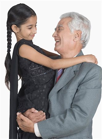 Senior man carrying his granddaughter and smiling Stock Photo - Premium Royalty-Free, Code: 630-03479661
