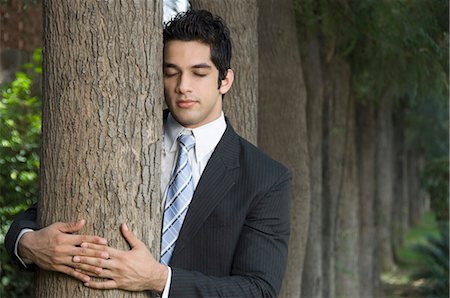 Businessman hugging a tree Stock Photo - Premium Royalty-Free, Code: 630-03479839