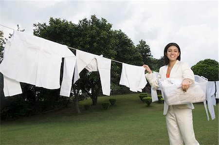 Businesswoman hanging washed cloths before going to work Stock Photo - Premium Royalty-Free, Code: 630-03479878