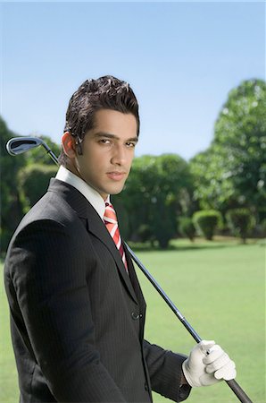 Businessman holding a golf club in a golf course Stock Photo - Premium Royalty-Free, Code: 630-03479897