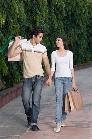 road together - Couple carrying shopping bags and smiling Stock Photo - Premium Royalty-Free, Code: 630-03479937