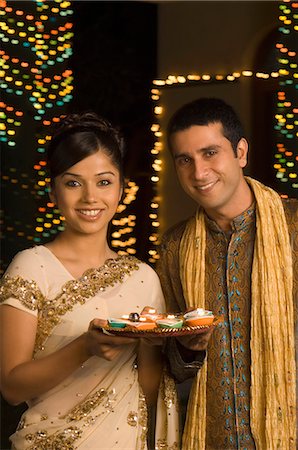 saree couples - Couple holding religious offering and smiling Stock Photo - Premium Royalty-Free, Code: 630-03480208