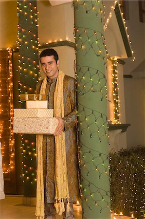 Man holding gifts and smiling Stock Photo - Premium Royalty-Free, Code: 630-03480221