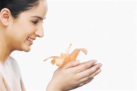 sonrisa sardónica - Side profile of a woman holding a flower Foto de stock - Sin royalties Premium, Código: 630-03480261