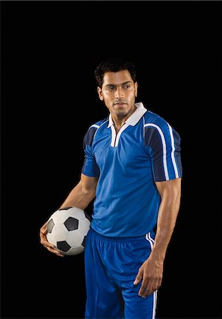 soccer player holding ball - Homme tenant un ballon de soccer Photographie de stock - Premium Libres de Droits, Code: 630-03480321