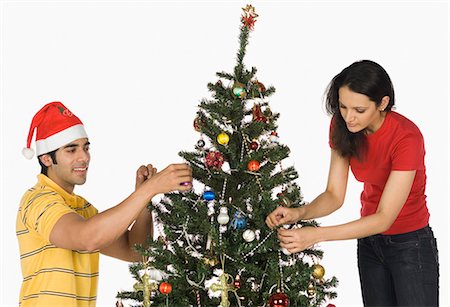 Couple decorating a Christmas tree Stock Photo - Premium Royalty-Free, Code: 630-03480394